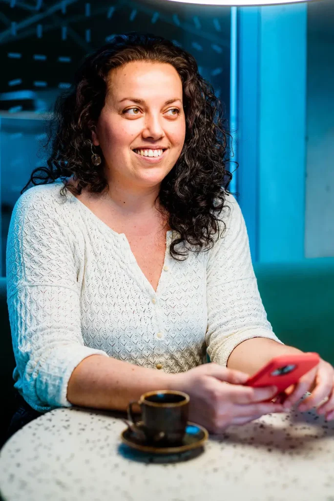 Florence Billard, rédactrice web SEO chez Sillages, en train de répondre à un message devant un café