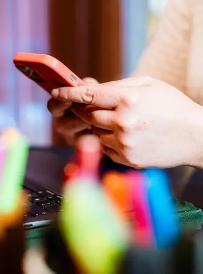 Gros plan sur les mains de Florence, en train d'écrire un mail sur son téléphone