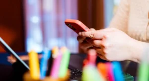 Gros plan sur les mains de Florence Billard, en train de rédiger l'article de blog sur les conseils pour apparaître sur Google